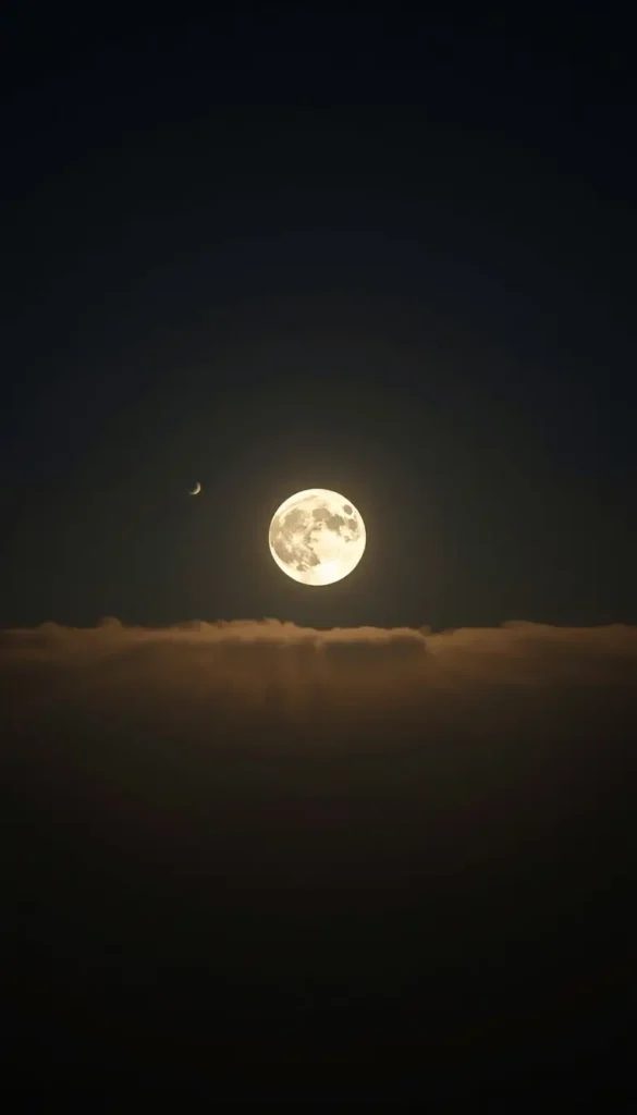 moon-light-photos of full moon above clouds with small crescent in night sky